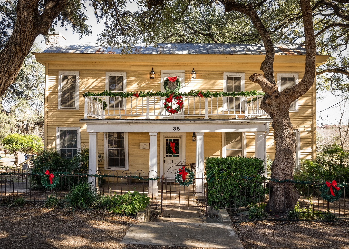 Yellow historic home decorated for Christmas